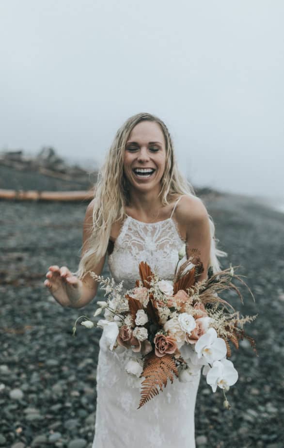 Bride laughing on the beach during her elopement on Ruby Beach