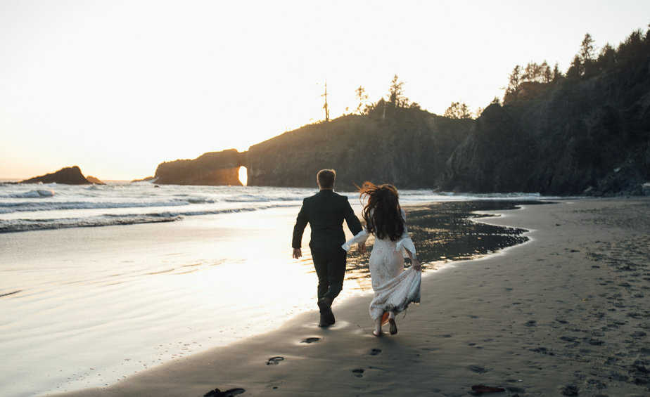 Bride and groom stroll on Second Beach in La Push, WA