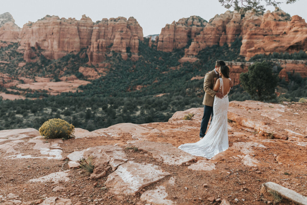 Bride and groom on edge of cliff during their elopement in Sedona, Arizona.