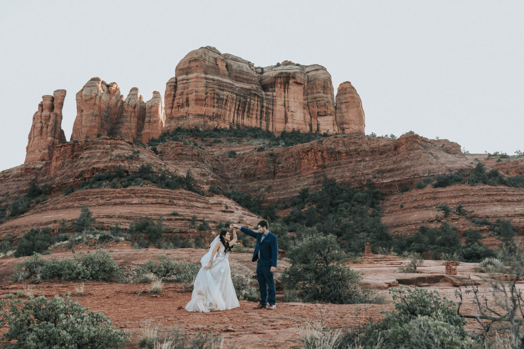 A bride and groom dance in front of the redrocks of Sedona, Arizona during their wedding.