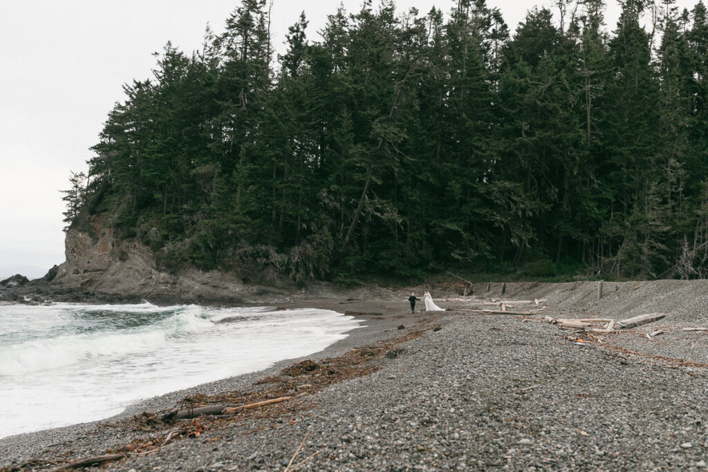 Bride and groom walk along the private beach at Agate Beach Lodge in Port Angeles, WA.