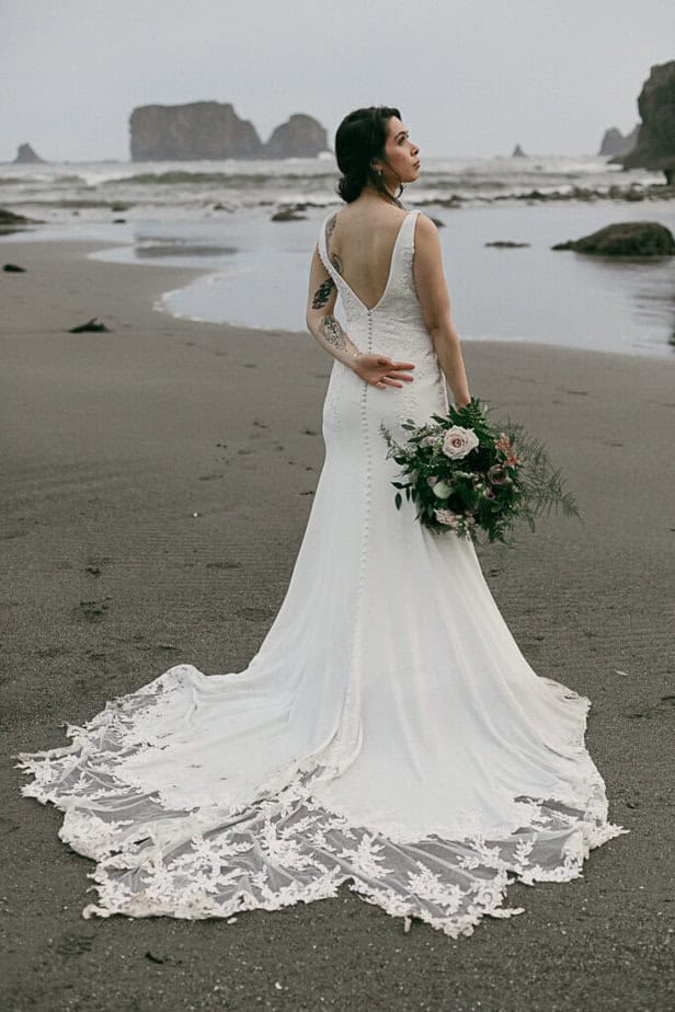 A bride poses on the beach in Olympic National Park.