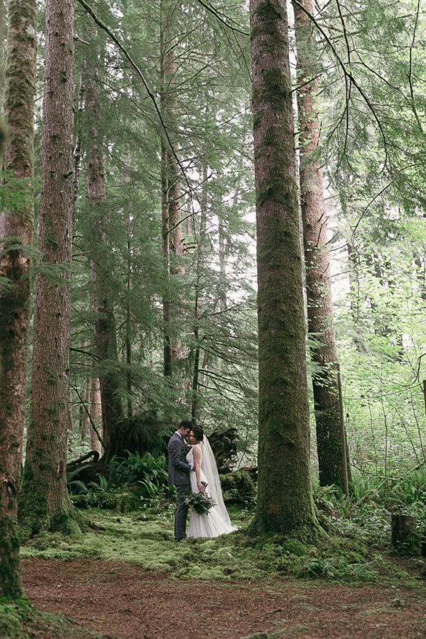 Bride and groom pose in the forest in Forks, Washington.