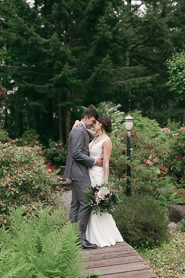 A couple poses in the gardens of Fern Acres during their intimate wedding in Forks, Washington.