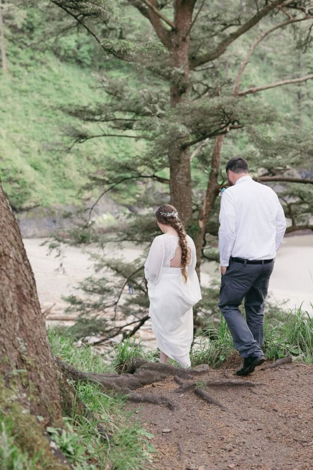 An eloping couple hike down to their ceremony location in Cape Disappointment. 