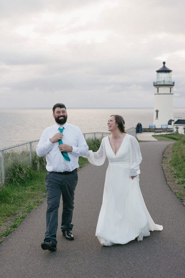 Bride and groom laugh while walking during their elopement at Cape Disappointment. 