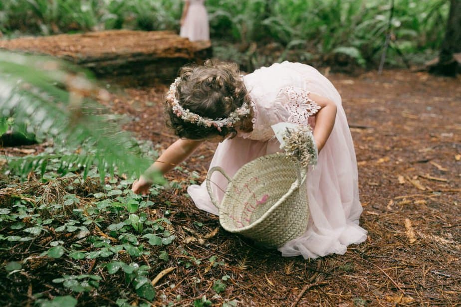 Flower girl picks up leaves in Olympic National Park in Port Angeles, Washington.