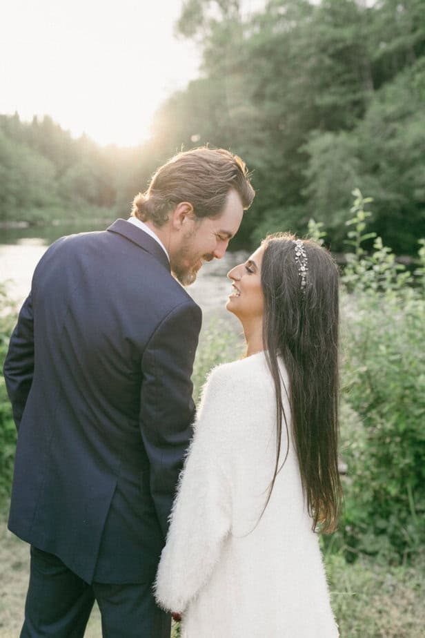 Bride and groom look out on Hoh River in Forks, Washington during their elopement.