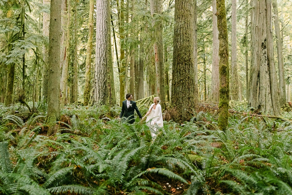 Elopement couple walk hand in hand in Olympic National Park.