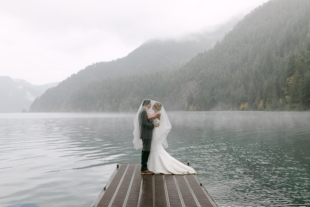 bride and groom pose for portraits along the shores of Lake Crescent in Port Angeles, Washington.