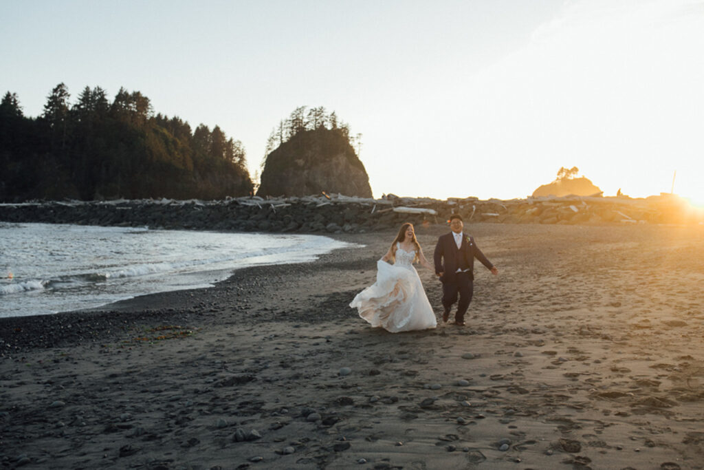 Bride and groom run along the beach of First Beach in Olympic National Park. 